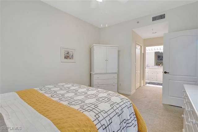 carpeted bedroom with ensuite bath and ceiling fan