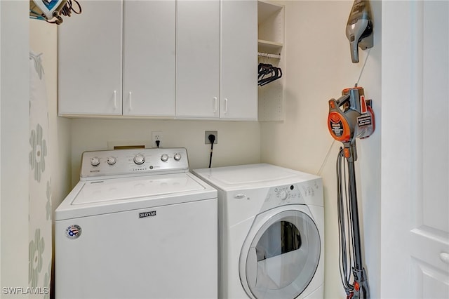 laundry area with washer and dryer and cabinets