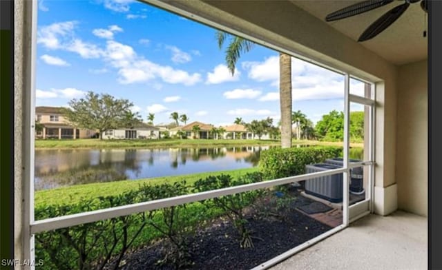 unfurnished sunroom featuring a water view and ceiling fan