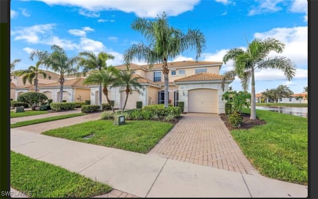 mediterranean / spanish house featuring a front lawn and a garage