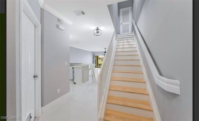 staircase featuring crown molding