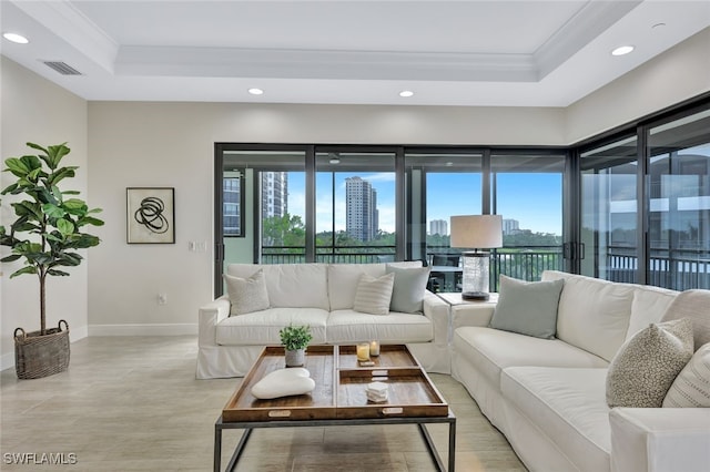 living room with ornamental molding and a tray ceiling