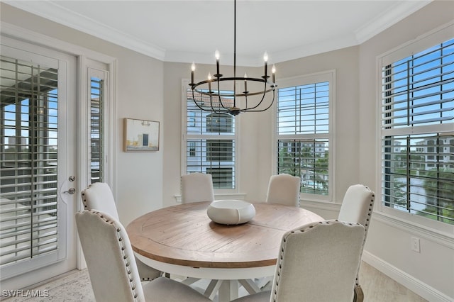 dining space with ornamental molding and an inviting chandelier