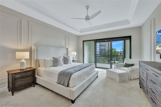 carpeted bedroom with ceiling fan, a raised ceiling, and access to outside