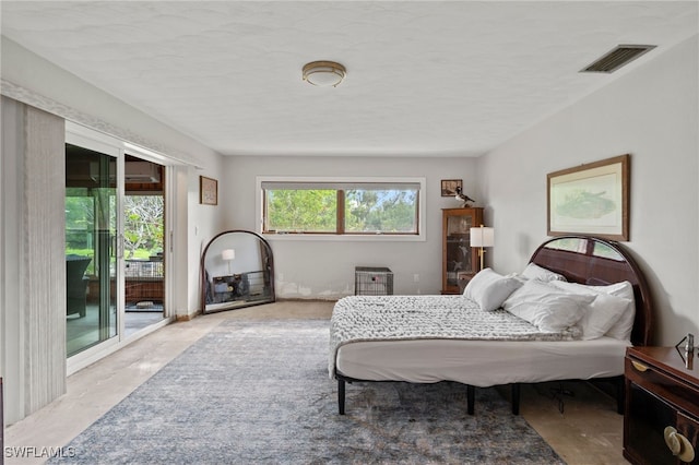 bedroom featuring access to exterior and a textured ceiling