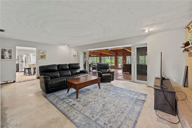 living room with a fireplace and a textured ceiling