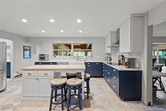 kitchen with butcher block countertops, appliances with stainless steel finishes, a healthy amount of sunlight, and blue cabinets