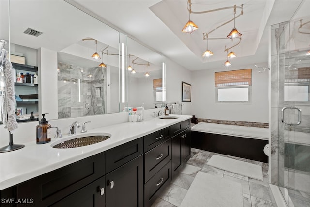 bathroom featuring a raised ceiling, vanity, and independent shower and bath