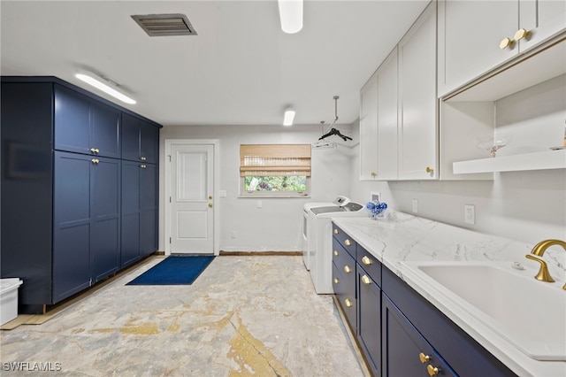 laundry room with cabinets, washing machine and dryer, and sink