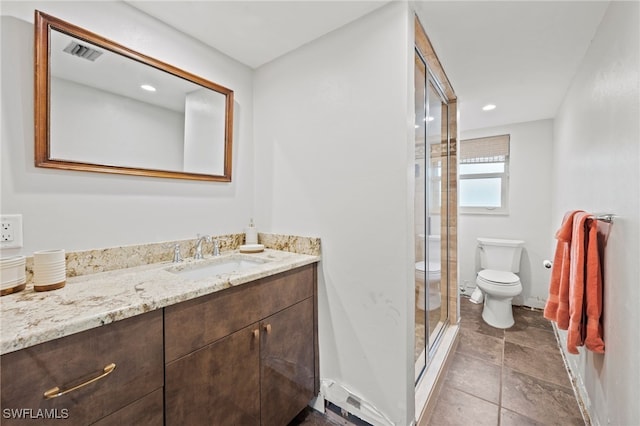 bathroom with vanity, a shower with shower door, and toilet