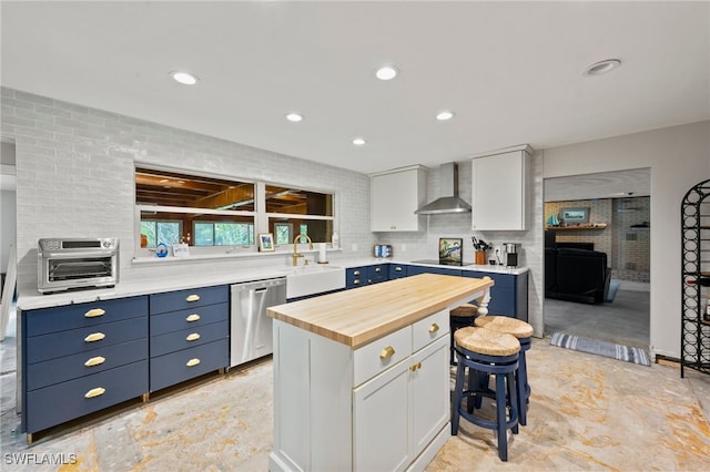 kitchen featuring dishwasher, a center island, white cabinetry, and wall chimney exhaust hood