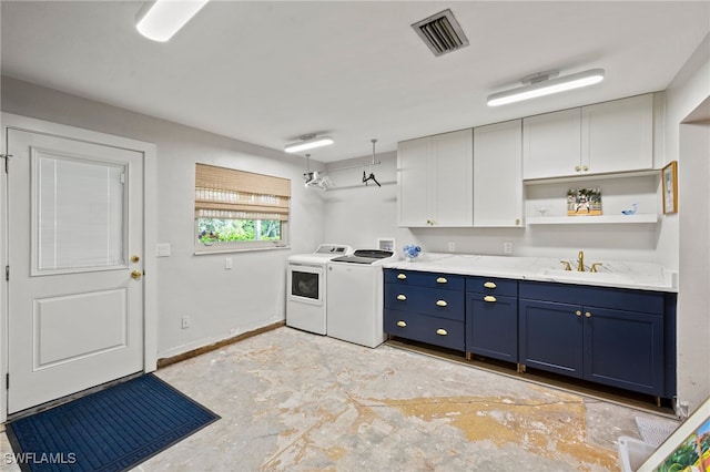 kitchen featuring white cabinets, washer and dryer, sink, and blue cabinetry