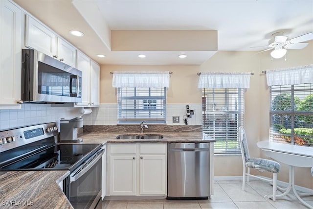 kitchen with white cabinets, sink, backsplash, and appliances with stainless steel finishes