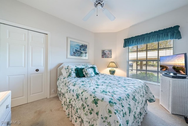 bedroom featuring ceiling fan, light carpet, and a closet