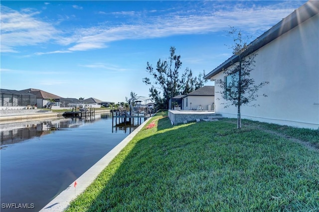 exterior space featuring a lawn and a water view