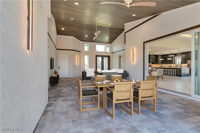 dining area featuring ceiling fan, wooden ceiling, and high vaulted ceiling