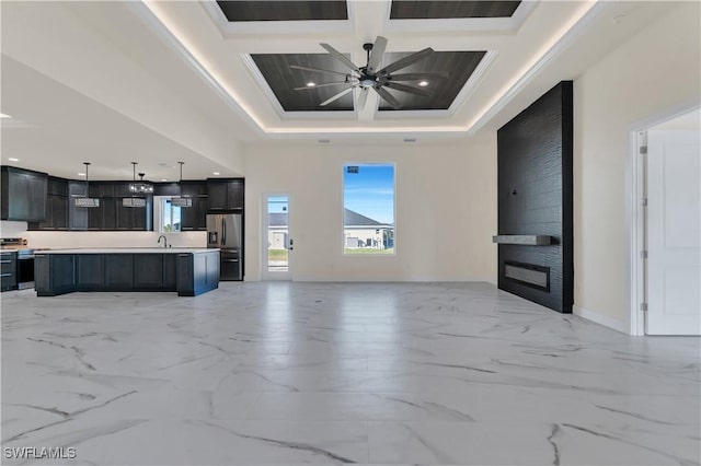 unfurnished living room featuring a fireplace, ornamental molding, coffered ceiling, ceiling fan, and beamed ceiling