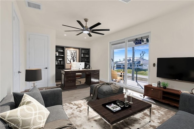 living room with ceiling fan and light hardwood / wood-style flooring