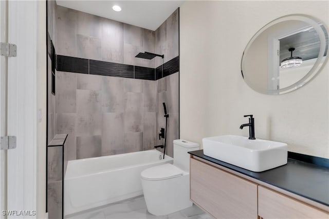 full bathroom featuring vanity, tiled shower / bath combo, and toilet