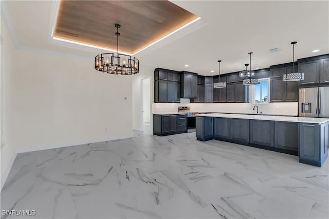 kitchen featuring a raised ceiling, hanging light fixtures, and appliances with stainless steel finishes