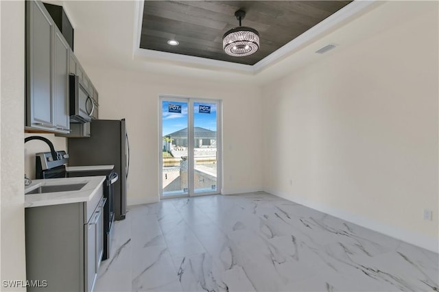 kitchen with stainless steel appliances, a tray ceiling, an inviting chandelier, wooden ceiling, and gray cabinets