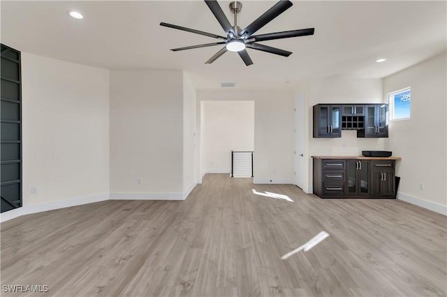 unfurnished living room with ceiling fan and light hardwood / wood-style flooring