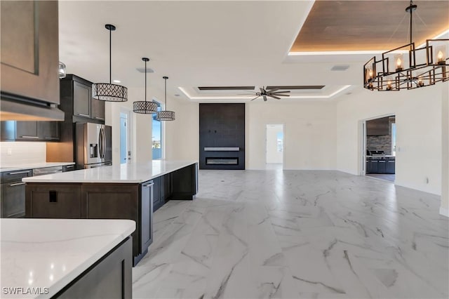 kitchen with stainless steel fridge with ice dispenser, a tray ceiling, hanging light fixtures, and a large island