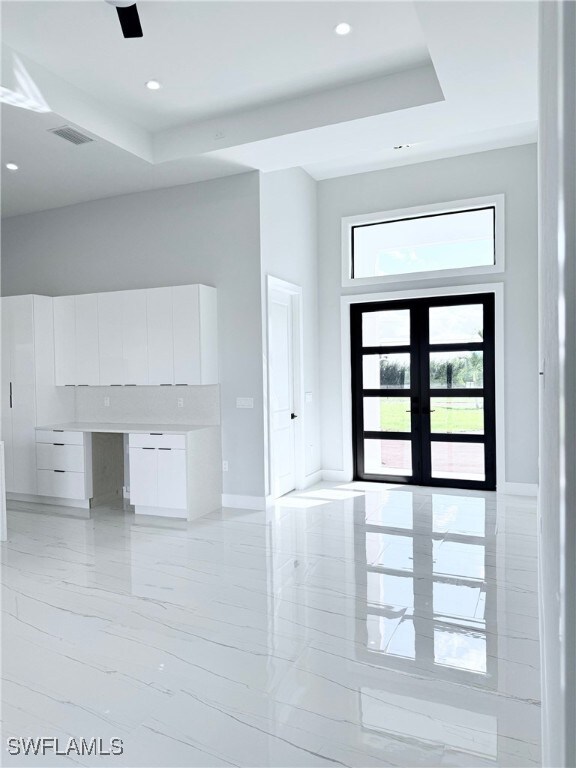 entryway featuring a raised ceiling and french doors