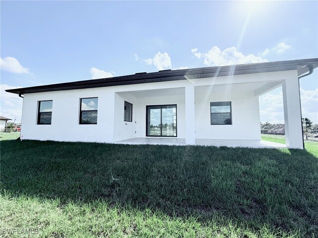 rear view of house featuring a patio area and a lawn