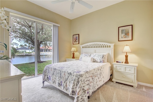 bedroom with ceiling fan, access to exterior, a water view, and light colored carpet