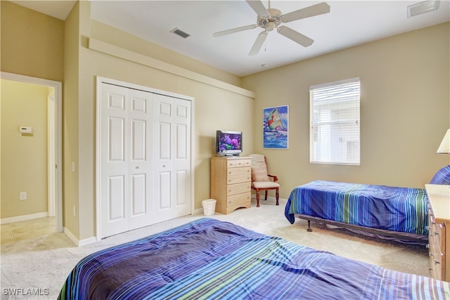 bedroom featuring light carpet, ceiling fan, and a closet