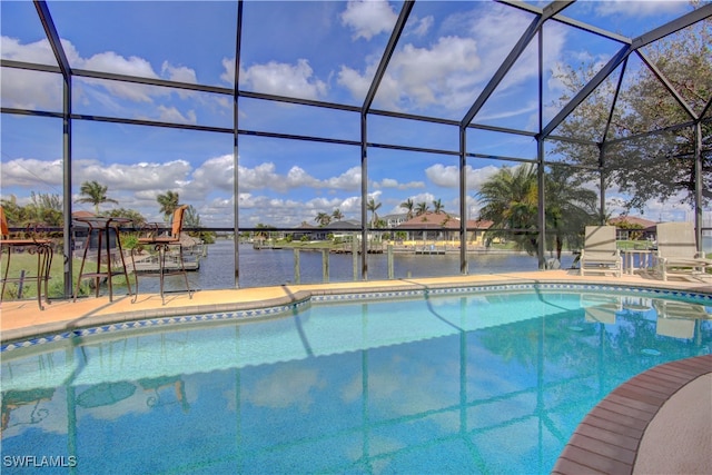 view of pool with a lanai, a water view, and a patio area