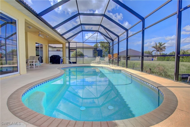 view of pool with glass enclosure, a patio, and ceiling fan