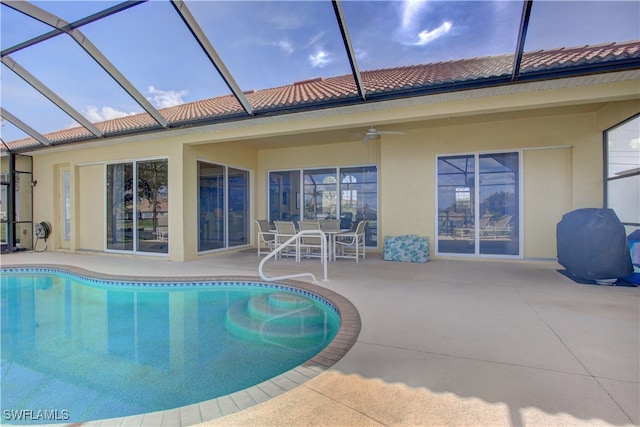 view of pool featuring a patio, ceiling fan, and glass enclosure