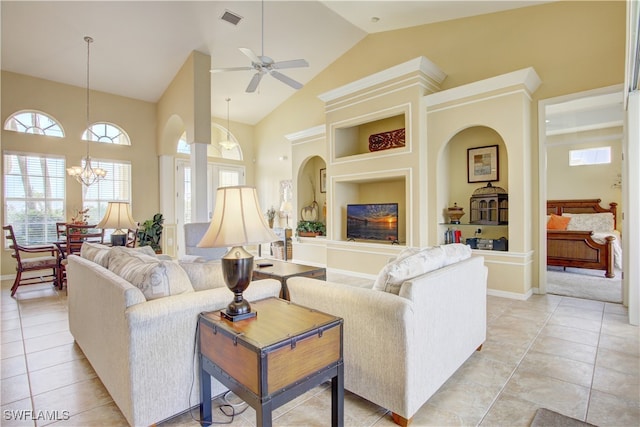 tiled living room featuring ceiling fan with notable chandelier and high vaulted ceiling