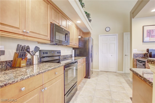 kitchen with light brown cabinets, light tile patterned floors, black appliances, and light stone counters