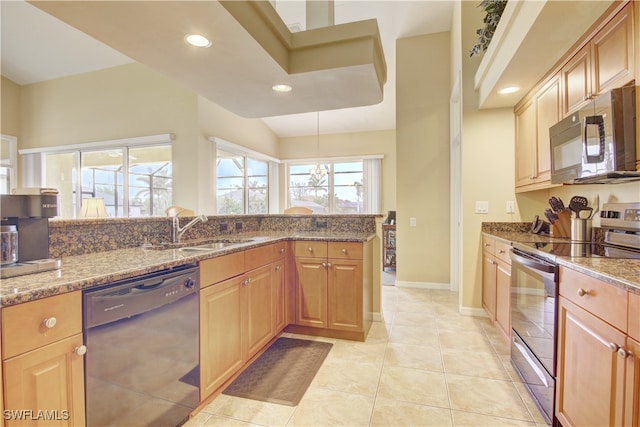 kitchen with light stone countertops, light brown cabinetry, light tile patterned floors, and appliances with stainless steel finishes