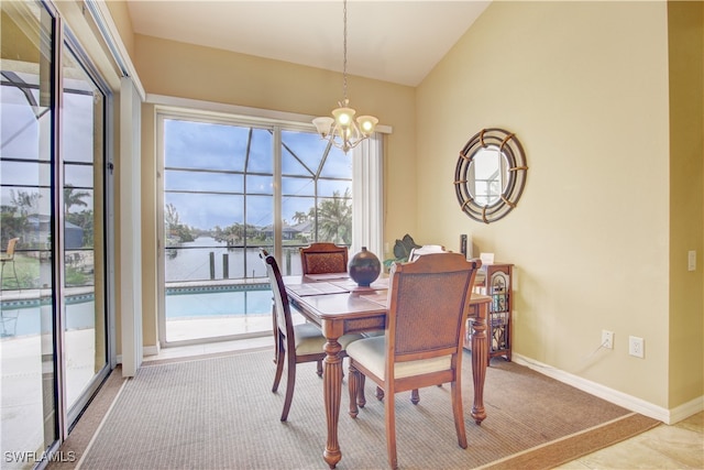 carpeted dining area with a wealth of natural light, vaulted ceiling, and a notable chandelier