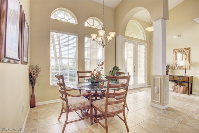 tiled dining area featuring french doors, a chandelier, and a high ceiling