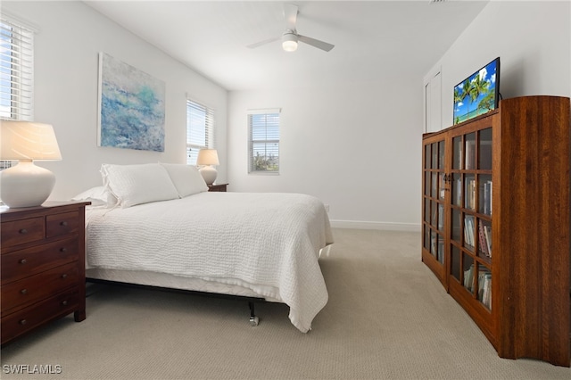 carpeted bedroom featuring ceiling fan and multiple windows