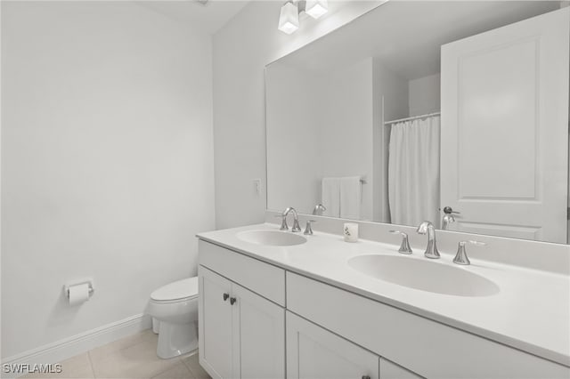 bathroom with tile patterned flooring, vanity, and toilet