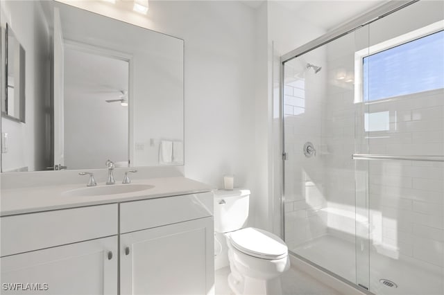 bathroom featuring ceiling fan, toilet, walk in shower, and vanity