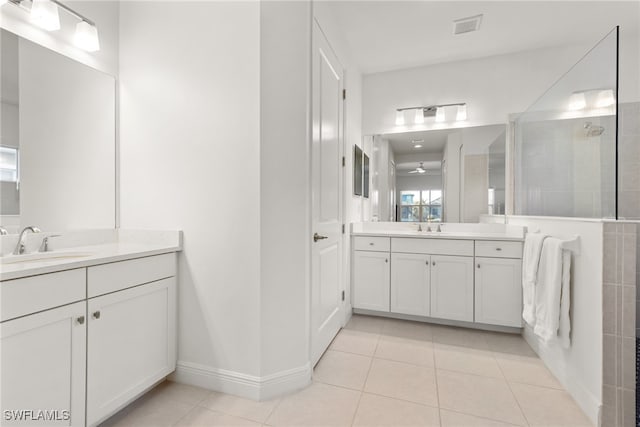 bathroom with tile patterned floors, vanity, and tiled shower