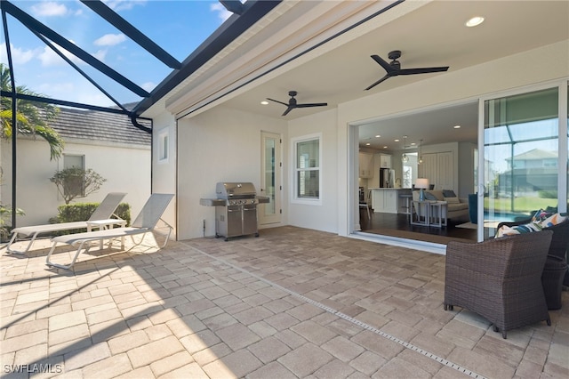 view of patio / terrace with a grill, ceiling fan, and glass enclosure