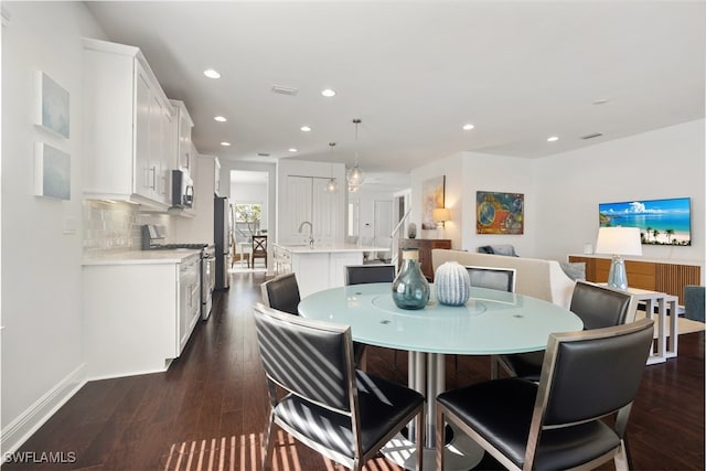 dining area with dark hardwood / wood-style flooring and sink