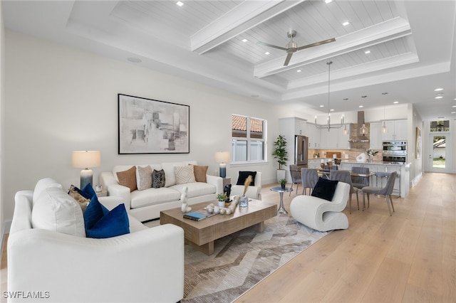 living room with a raised ceiling, light hardwood / wood-style flooring, ceiling fan, beam ceiling, and wood ceiling