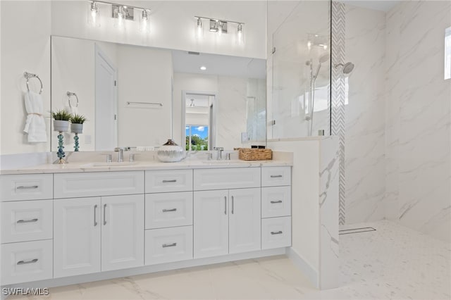 bathroom featuring a marble finish shower, marble look tile flooring, and double vanity