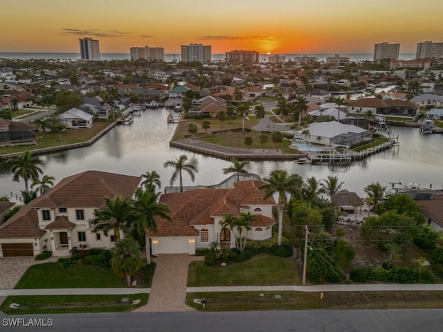 aerial view at dusk featuring a water view