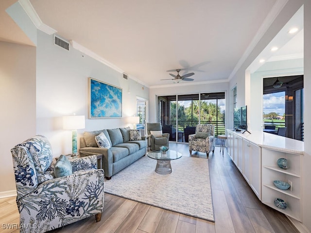 living room featuring ceiling fan, ornamental molding, and hardwood / wood-style floors