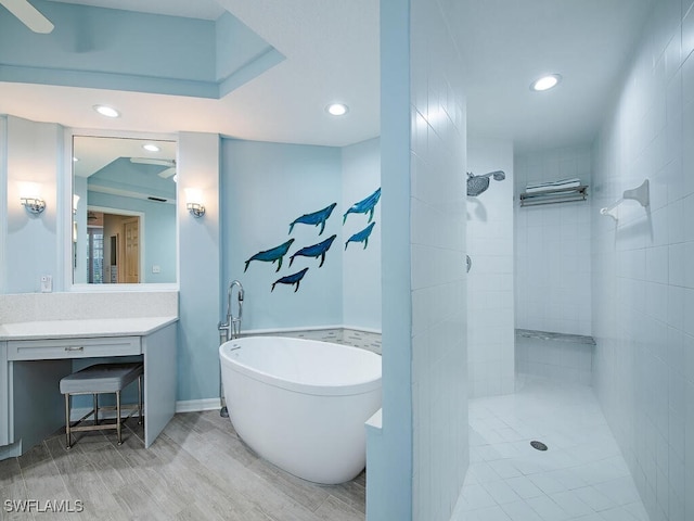 bathroom featuring wood-type flooring, shower with separate bathtub, and vanity